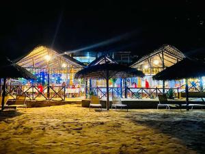 a building with chairs and umbrellas at night at Tropical Paradise Nosy Be in Nosy Be