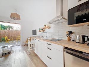 een keuken met witte kasten en een aanrechtblad bij Charmant studio Bernerie-en-Retz in La Bernerie-en-Retz