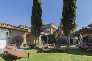 un grupo de bancos frente a una casa en Collection O Hotel La Huerta Golf & Hotel, Cholula, en Cholula