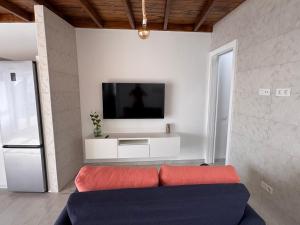 a living room with a couch and a tv on a wall at Marina in La Santa