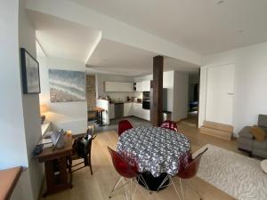 a kitchen and living room with a table and chairs at L'escapade Saint Michel in Val Couesnon
