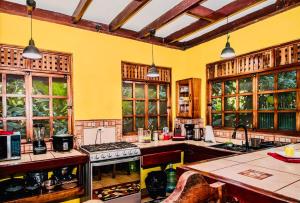 une grande cuisine avec des murs et des fenêtres jaunes dans l'établissement Elita luxurious villa, pool, jacuzzi, AC wellness, à Talamanca
