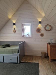 a bedroom with a bed and a window in a attic at Otwarte Okiennice Soce 74 in Soce