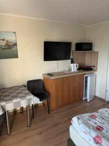 ein Hotelzimmer mit einem Bett und einem Fernseher in der Unterkunft Pokoje gościnne Antonia in Władysławowo