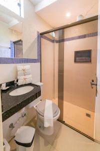 a bathroom with a toilet and a sink and a shower at Pousada Ponta de Mangue in Maragogi