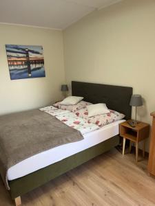 ein Schlafzimmer mit einem Bett und einem Tisch mit einer Lampe in der Unterkunft Pokoje gościnne Antonia in Władysławowo