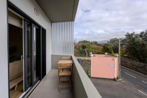 a balcony with a table and a view of a road at Nono Guest House in Ribeira Grande +10 photos