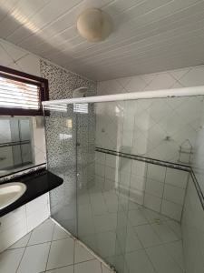 a bathroom with a glass shower and a sink at Casa Araçagy in São-José-do-Ribamar