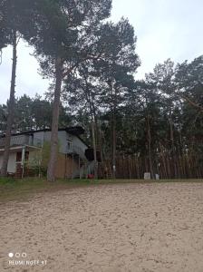 a house on the beach with a fence and trees at Apartament Słoneczny Zakątek in Radzyń +3 photos