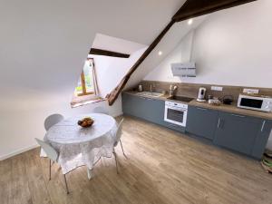 a kitchen with a table and chairs in a room at Le Logis de Trèfle in Azay-le-Rideau