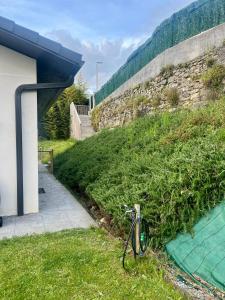 a bike parked in the grass next to a wall at Suite con Jardin privado y entrada privada in Plentzia