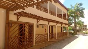 a building with wooden doors and a balcony at Cheguei Preá in Prea