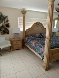 a bedroom with a canopy bed and a chair at Cape Coral villa with a 23ft sportsboat in Cape Coral