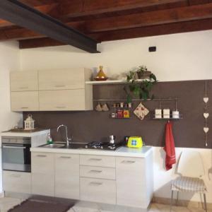 una cocina con armarios blancos y fregadero en Borghello 2Level Airport, en Bérgamo