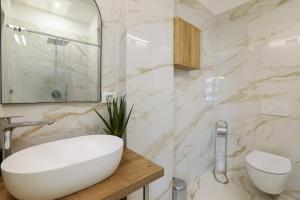 une salle de bain blanche avec un lavabo et un miroir dans l'établissement DUOMO View Luxury Suite, à Milan 5 autres photos
