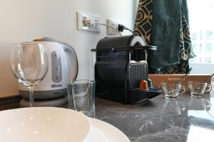 - un comptoir avec une cafetière et des verres dans l'établissement DUOMO View Luxury Suite, à Milan