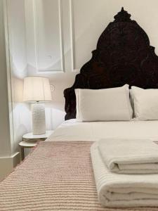 una camera da letto con un letto grande con testiera nera di Quarto Com Banheiro no Coração de Lisboa a Lisbona