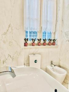 un bagno con vasca, lavandino e finestra di Quarto Com Banheiro no Coração de Lisboa a Lisbona