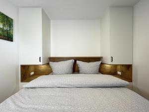 a bedroom with a large bed with white walls at Am Dahmer Leuchtturm 23f in Dahme