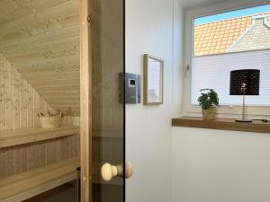 a door to a room with a window and a plant at Am Dahmer Leuchtturm 23f in Dahme +32 photos