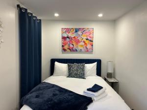 a bedroom with a bed with a painting on the wall at Serenity Charm - Walk in Town, Shaw, Hottub in Niagara-on-the-Lake +64 photos