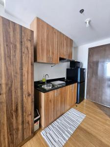 a kitchen with wooden cabinets and a sink and a refrigerator at The Loop 2204 - Goff's Place in Cagayan de Oro