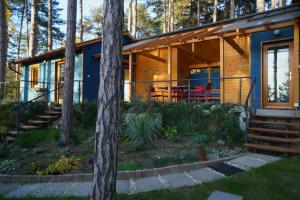 a log cabin in the woods with a porch at Surányi kék házak in Pócsmegyer