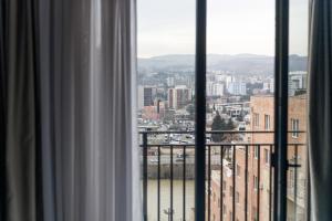 a view of a city from a window at Address Inn in Tbilisi City