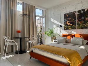 罗兹Apartament I LOVE PIOTRKOWSKA z wielkim lustrem, balkonem i klimatyzacją的一间卧室配有一张大床和一张桌子及椅子
