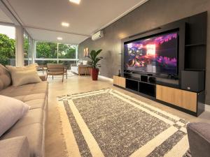 ein Wohnzimmer mit einem großen Flachbildfernseher in der Unterkunft Luxo e segurança - 30 minutos de SP in Carapicuíba