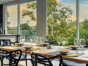 ein Esszimmer mit einem Tisch mit Weingläsern in der Unterkunft Luxo e segurança - 30 minutos de SP in Carapicuíba