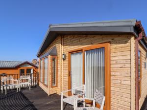 a wooden cabin with benches on a deck at Percy Wood Country Park in Newton on the Moor