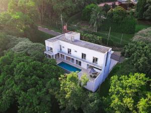 eine Aussicht auf ein weißes Haus im Wald in der Unterkunft Luxo e segurança - 30 minutos de SP in Carapicuíba