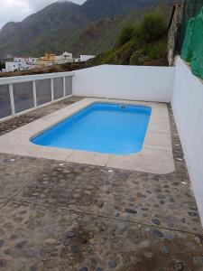 a blue swimming pool on the side of a building at Casa lucas in Almáciga