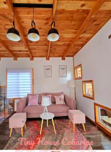 a living room with a couch and two chairs at Tiny house in Coñaripe