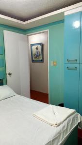a bedroom with a white bed and a blue wall at Lovely house in Pagadian city in Norte