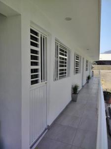 Un pasillo de un edificio blanco con ventanas. en Casa los Sauces, en Tepic