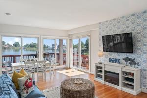 a living room with a couch and a tv and a table at Waterfront Getaway - Dock UR Boat & Walk to Beach in Annapolis
