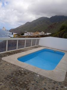 a blue swimming pool next to the ocean at Casa lucas in Almáciga