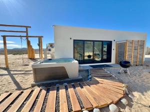 a tv sitting on a wooden deck in the desert at Private Jacuzzi Suite Steps to the Beach in La Ventana