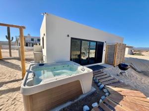 a hot tub on a deck in front of a house at Private Jacuzzi Suite Steps to the Beach in La Ventana