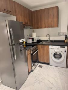 una cocina con nevera y lavadora en Unique 2bd Jacuzzi & Sunbed, en Abu Dabi