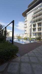 un edificio con piscina al lado de un edificio en Unique 2bd Jacuzzi & Sunbed, en Abu Dabi 12 fotos más