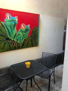 a table and two chairs and a painting of frogs at Playa Grande Ocean Break 2 min walk to beach in Playa Grande