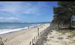 ein Strand, an dem Menschen auf dem Sand und dem Meer spazieren gehen in der Unterkunft House Pula in Venturina Terme