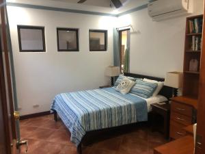 a bedroom with a bed with a blue blanket at Playa Grande Ocean Break 2 min walk to beach in Playa Grande