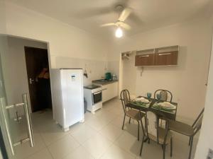 a kitchen with a table and a white refrigerator at Apartamento em Alagoinhas in Alagoinhas