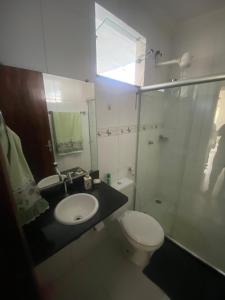 a bathroom with a toilet and a sink and a shower at Apartamento em Alagoinhas in Alagoinhas +1 photo