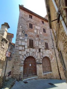 ein altes Steingebäude mit zwei Holztüren in der Unterkunft House Pula in Venturina Terme