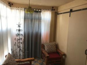 a living room with a chair and a window at La Adornada Girasol in Taxco de Alarcón